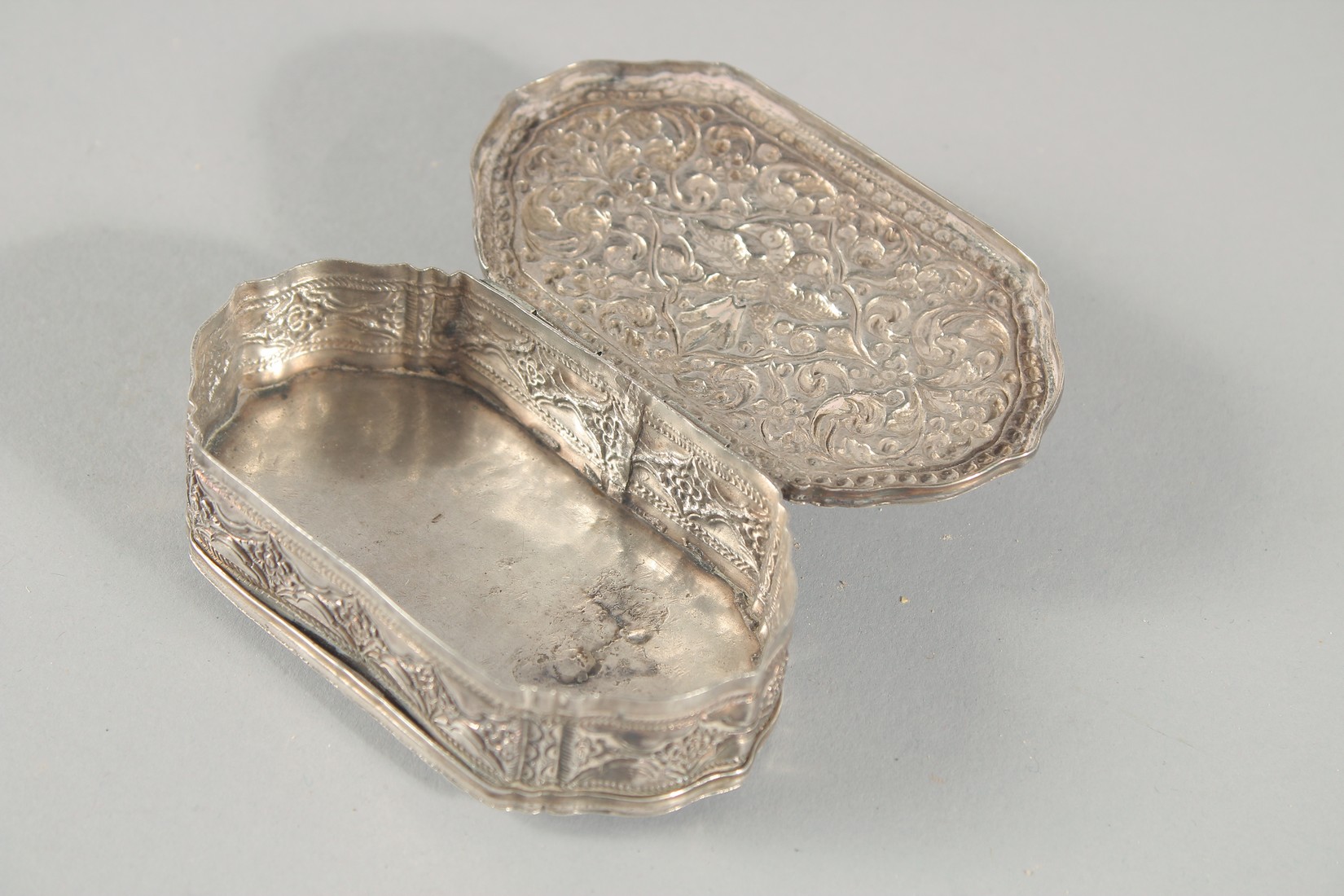 A FINE 19TH CENTURY SRI LANKAN SILVER BOX, with embossed foliate decoration, weight 55g, 9cm x 5cm. - Image 2 of 3