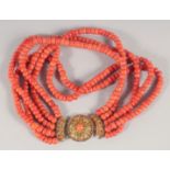 A FIVE STRAND CORAL BEAD NECKLACE WITH 18CT GOLD CLASP. 40cm long