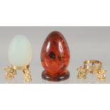 A PAIR OF OPAL AND AMBER EGGS on a stand.