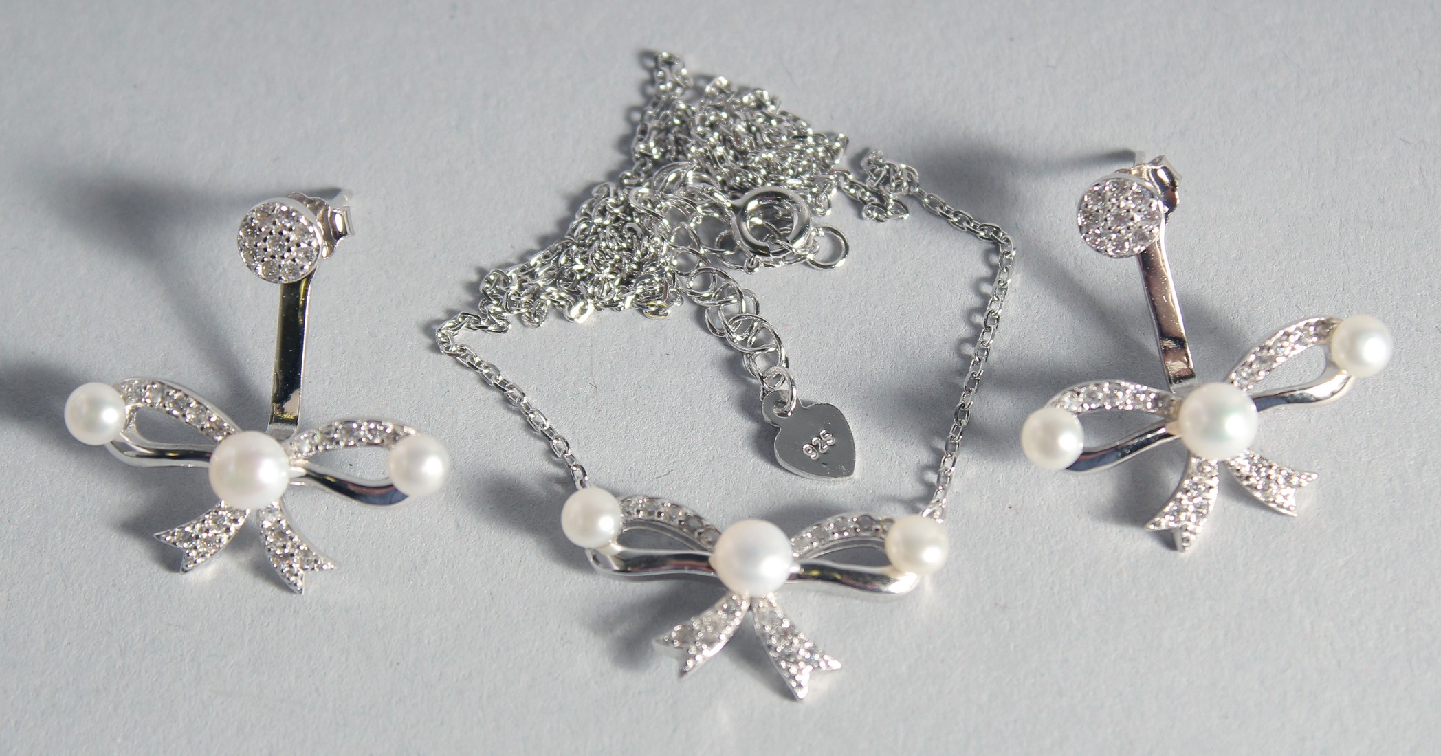 A SILVER BOW NECKLACE AND PAIR OF EARRINGS.