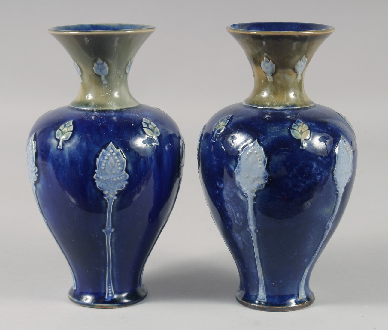 A PAIR OF ROYAL DOULTON STONEWARE BLUE VASES. 8ins high.