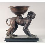 A BRONZE GROUP OF A MONKEY WITH A BOWL ON HIS BACK, standing on a marble base. 14.5ins long.