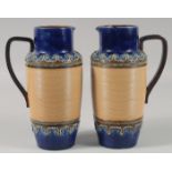 A PAIR OF ROYAL DOULTON STONEWARE JUGS with blue bands. 8ins high.