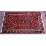 A PERSIAN DESIGN RUG, pink ground with geometric panels. 6'6" x 3'10"