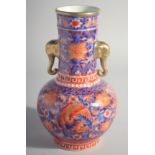 A CHINESE RED AND BLUE TWO HANDLED VASE with elephant handles. 9.5ins high.