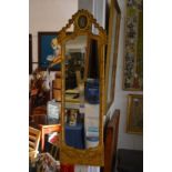A narrow gilt framed mirror with jasperware plaque.