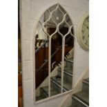 An arch shaped metal framed mirror.