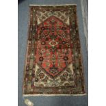 A small Persian woollen rug with stylised decoration 3'8" x 2'2".