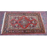 A good Persian carpet, rust ground with vases of flowers and floral border 7'2" x 4'5".