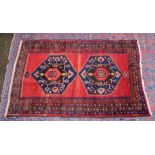 A good small Persian carpet, red ground with two large central medallions 7'2" x 4'3".