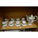 A parogan china coffee pot with eight matching cups and saucers.