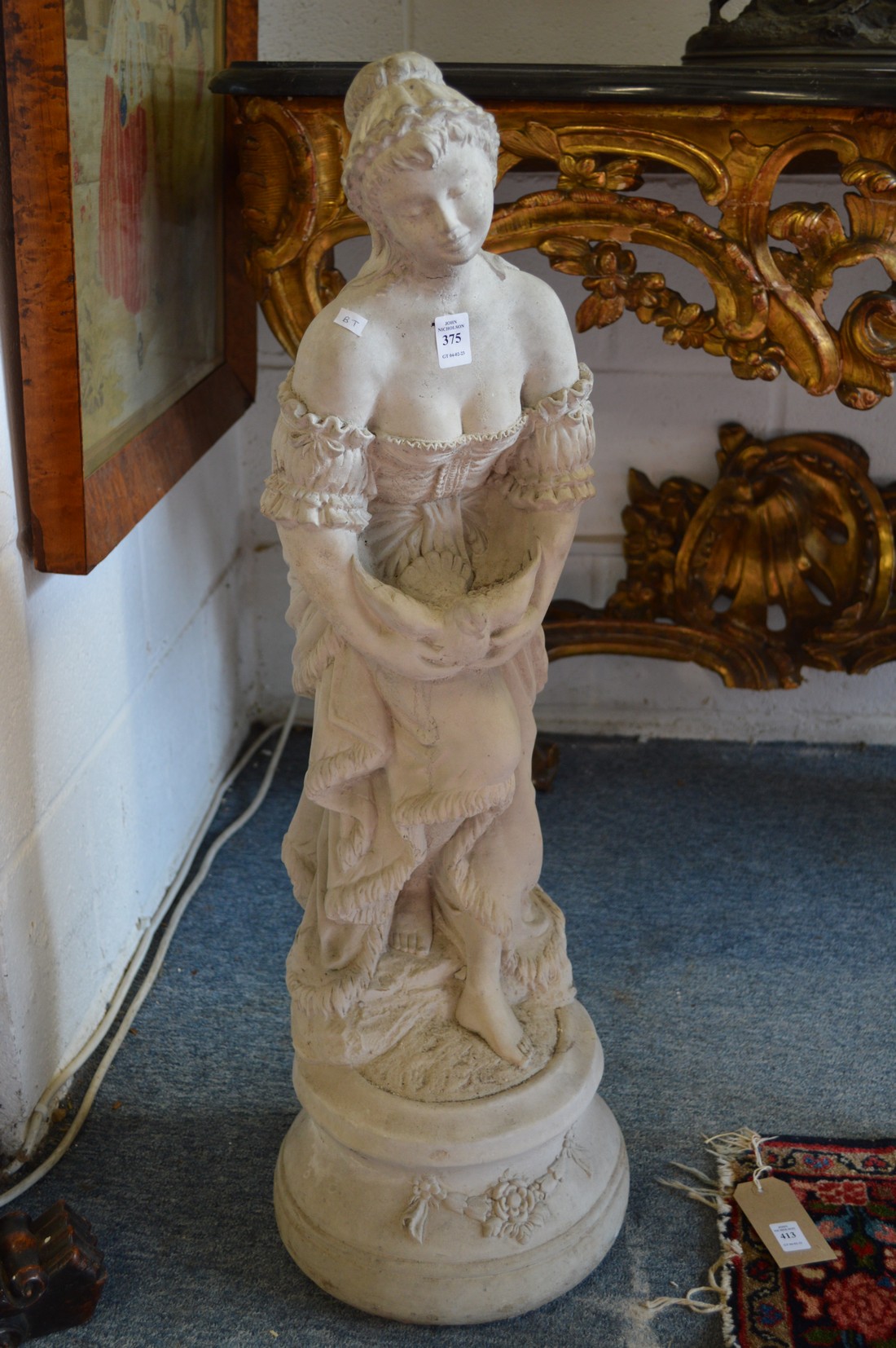 A cast composite statue modelled as a classical lady holding a dove.