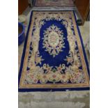 A blue ground floral decorated rug 7' x 4'.