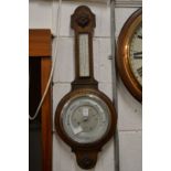 An oak cased barometer/thermometer.