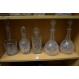 A pair of cut glass decanters and three others.
