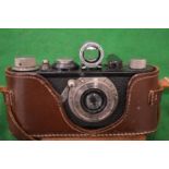 A Leitz Elmar 50mm camera with leather case.