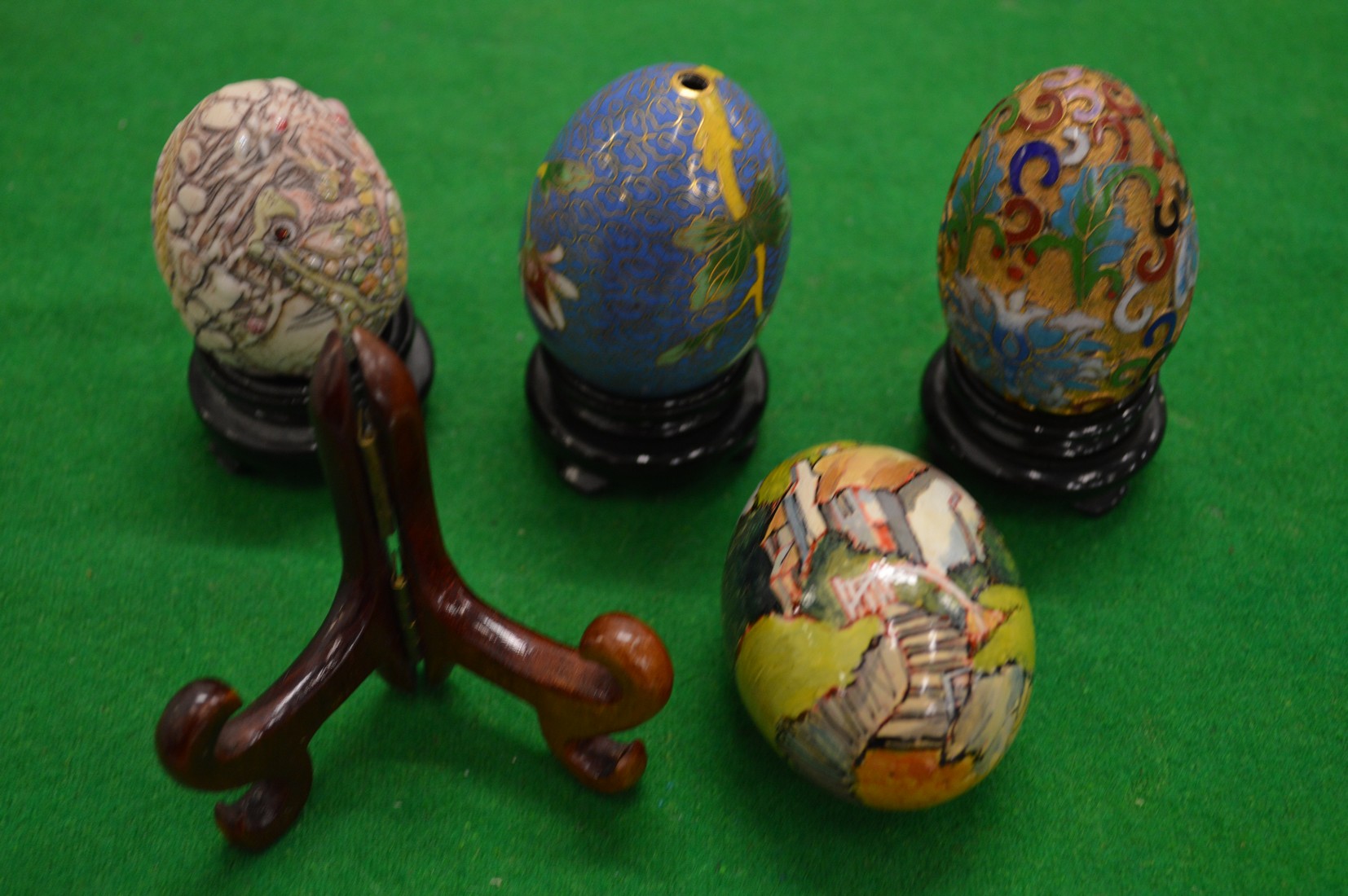 Cloisonne and other decorative eggs with stands.