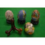 Cloisonne and other decorative eggs with stands.