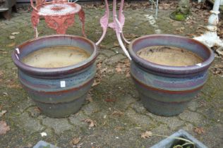 A pair of large glazed plant pots.