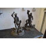 A pair of spelter figures depicting huntsmen and dogs.