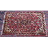 A Persian rug, pale red ground with all over stylised floral design 5'5" x 3'4".