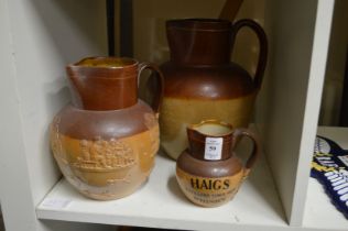 A small Doulton Lambeth Haigs whisky jug (rim chips), together with two similar larger Doulton