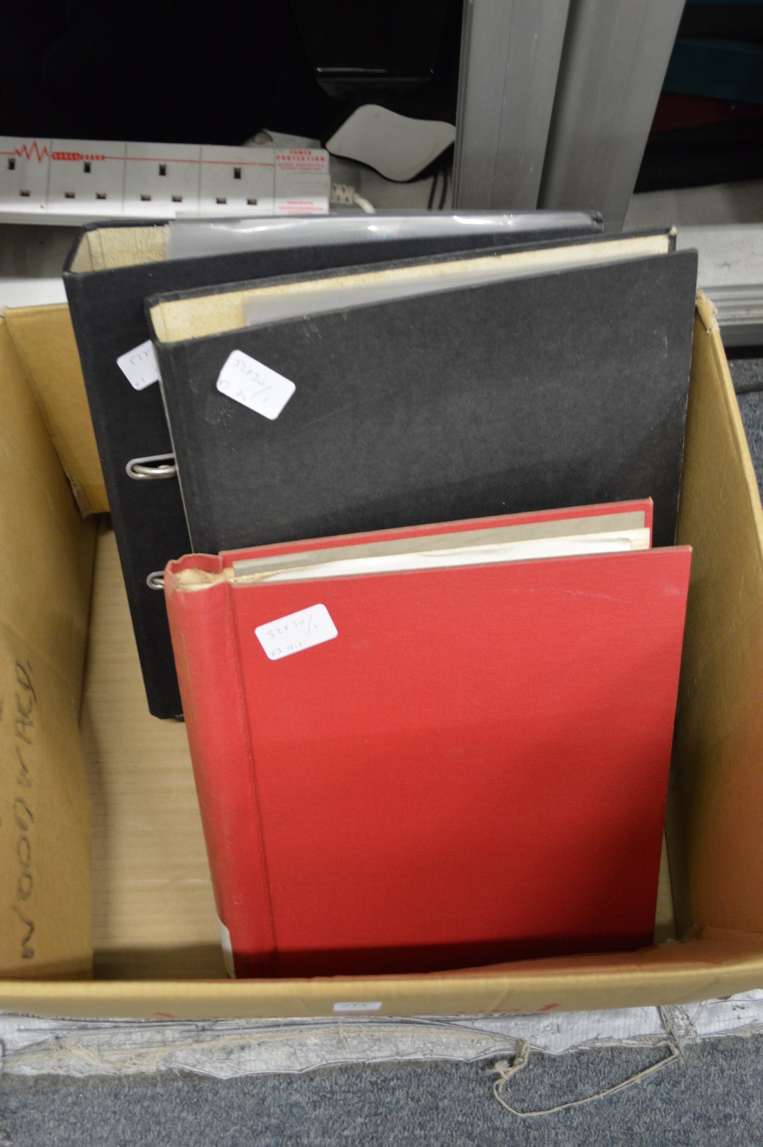 A red Simplex stamp album and two ring binders containing numerous stamps with annotated notes by