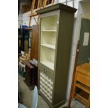 A green painted free standing kitchen unit with shelves, a draw and wine rack.