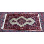 A small Indian rug, cream ground with floral decoration 4'4" x 2'3".