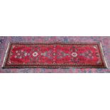 A Persian runner, bright red ground with stylised floral design 6'8" x 2'2".