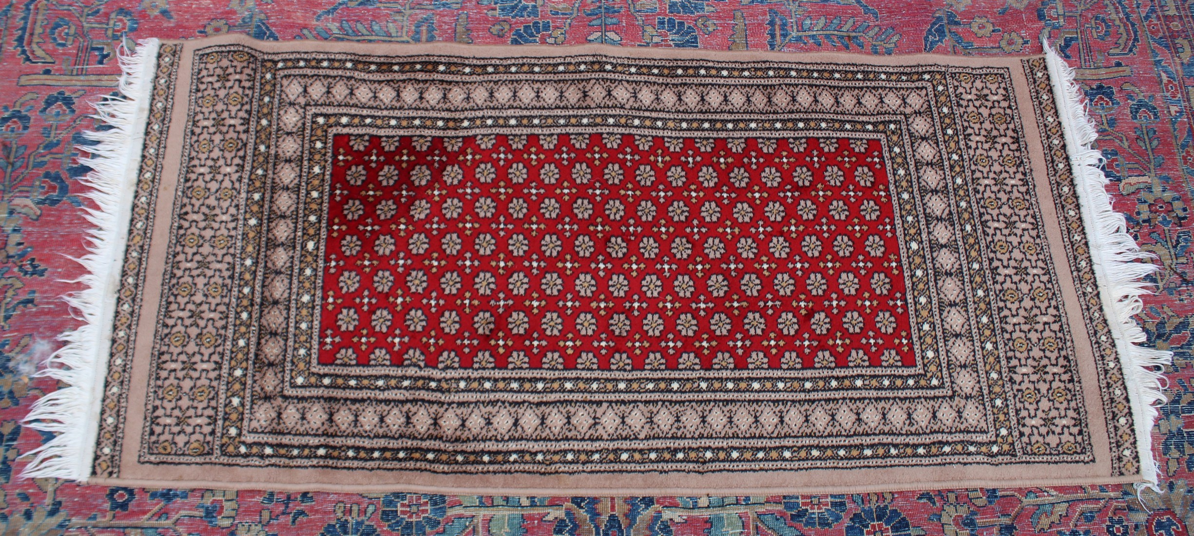 A modern Persian design rug, central red ground with all over stylised decoration 4'7" x 2'3".