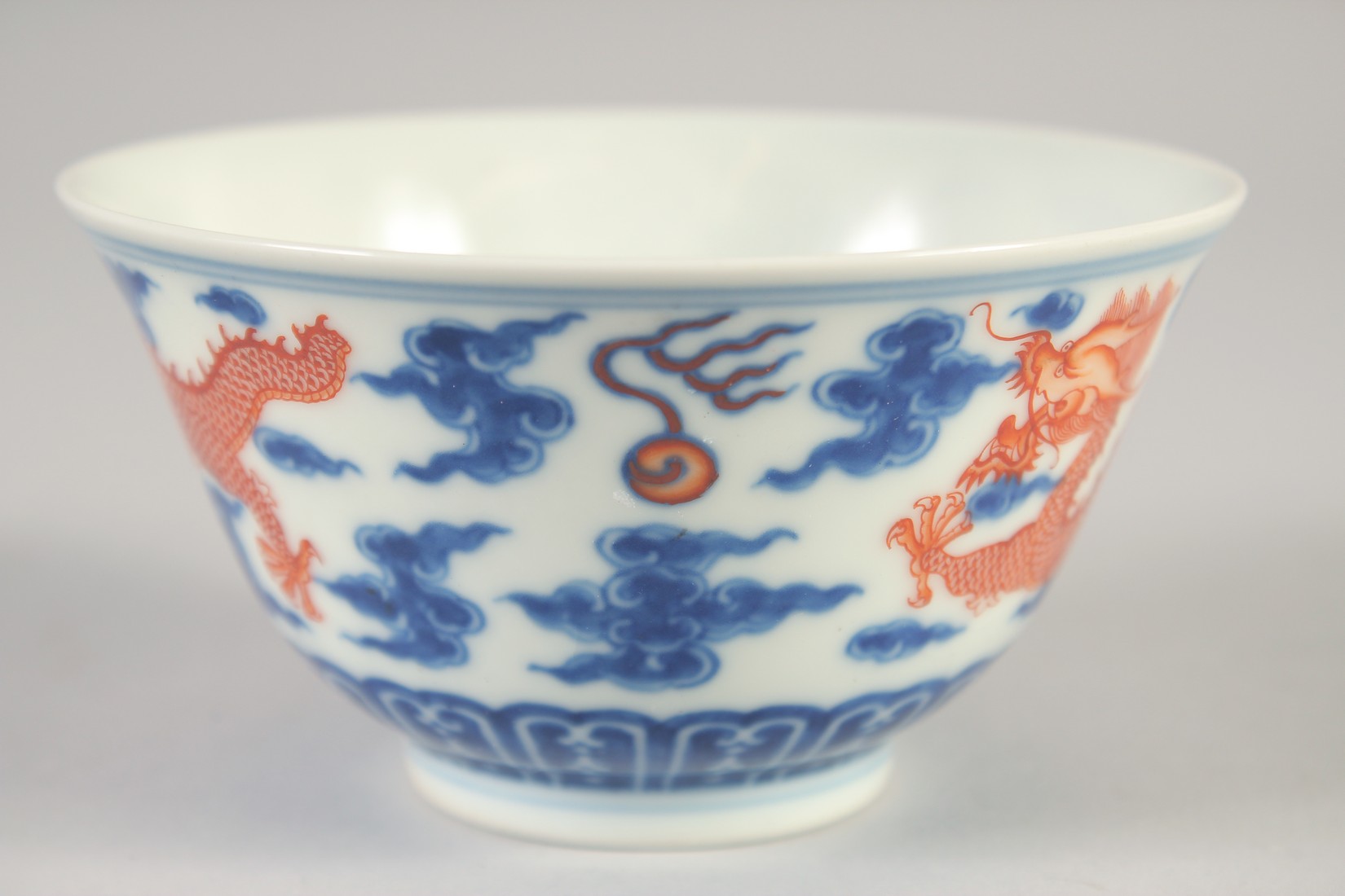 A CHINESE BLUE, WHITE AND IRON RED BOWL, with dragons and stylised clouds, Xuantong mark to base, - Image 2 of 7
