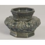 A CHINESE BRONZE OCTAGONAL CENSER, with panels of relief decoration, 13.5cm wide.