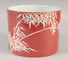 A CHINESE RED GROUND PORCELAIN BRUSH POT, decorated with bamboo, the base with six-character mark,