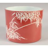 A CHINESE RED GROUND PORCELAIN BRUSH POT, decorated with bamboo, the base with six-character mark,