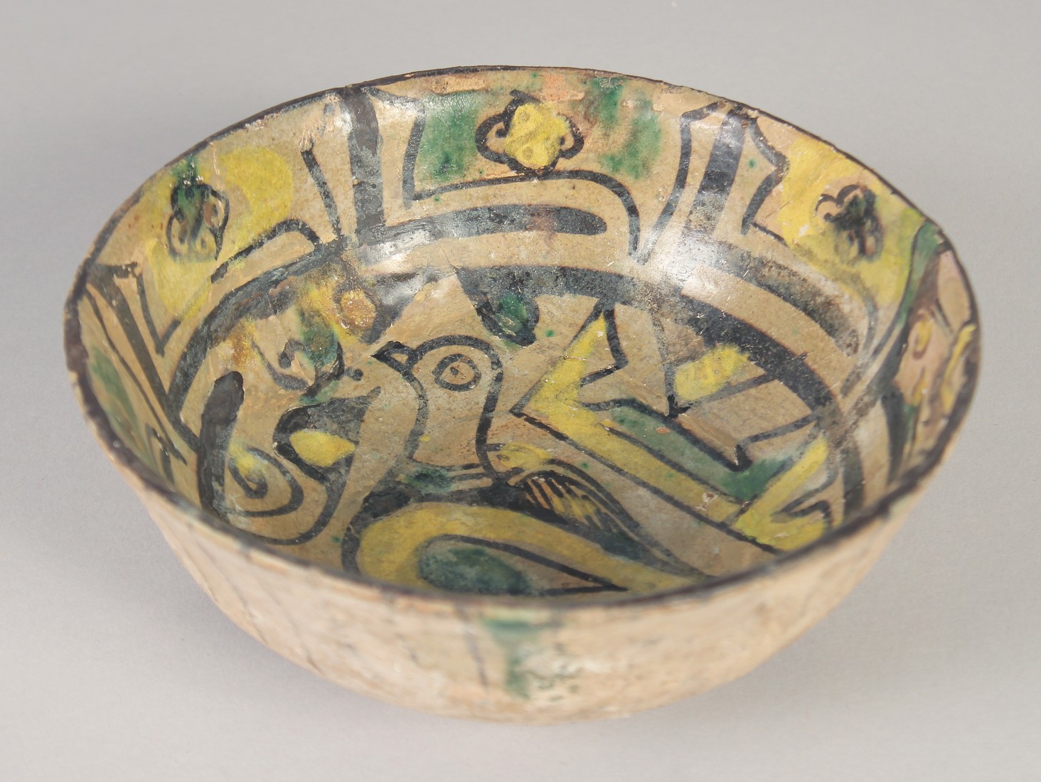 A FINE 9TH-10TH CENTURY PERSIAN NISHAPUR POTTERY BOWL, the interior painted with a bird, 15cm