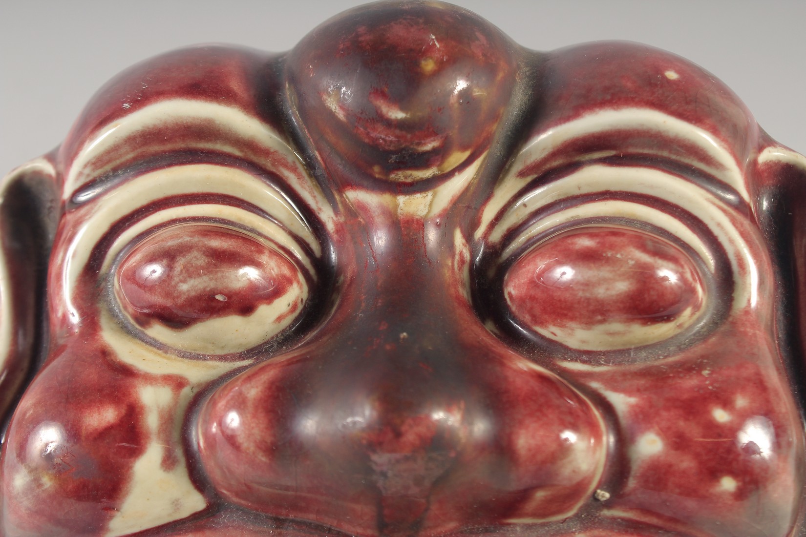 A CHINESE COPPER RED GLAZED POTTERY LION DOG MASK / WALL HANGING, 21cm wide. - Image 2 of 3