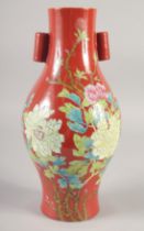 A CHINESE RED GROUND PORCELAIN TWIN HANDLE VASE, painted with flora, six-character mark to base,