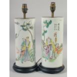 A PAIR OF CHINESE FAMILLE ROSE CYLINDRICAL PORCELAIN LAMP VASES, mounted to hardwood stands, each