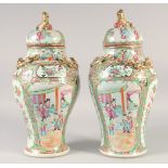 A PAIR CHINESE CANTON FAMILLE ROSE VASES AND COVERS, painted with panels of figures, the covers with