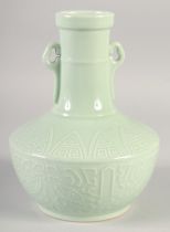 A CHINESE CELADON TWIN HANDLE VASE, with carved decoration, six-character mark to base, 24cm high.