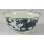 A CHINESE BLUE AND WHITE PORCELAIN BOWL, painted with beasts / animals, (af), 14cm diameter.