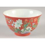 A CHINESE RED GROUND BOWL, painted with flora, four-character mark to base, 10cm diameter.