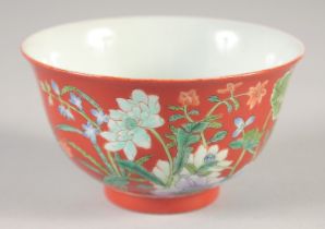 A CHINESE RED GROUND BOWL, painted with flora, four-character mark to base, 10cm diameter.
