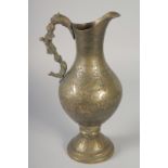 AN ISLAMIC ENGRAVED AND CHASED BRASS JUG, with figural handle, 28cm high.