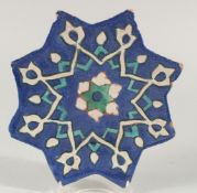 AN ISLAMIC GLAZED POTTERY STAR TILE, with foliate star form motif decoration, 24.5cm at widest