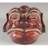 A CHINESE COPPER RED GLAZED POTTERY LION DOG MASK / WALL HANGING, 21cm wide.