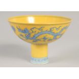 A CHINESE YELLOW GROUND BLUE AND WHITE STEM CUP, decorated with dragons, with six-character mark,