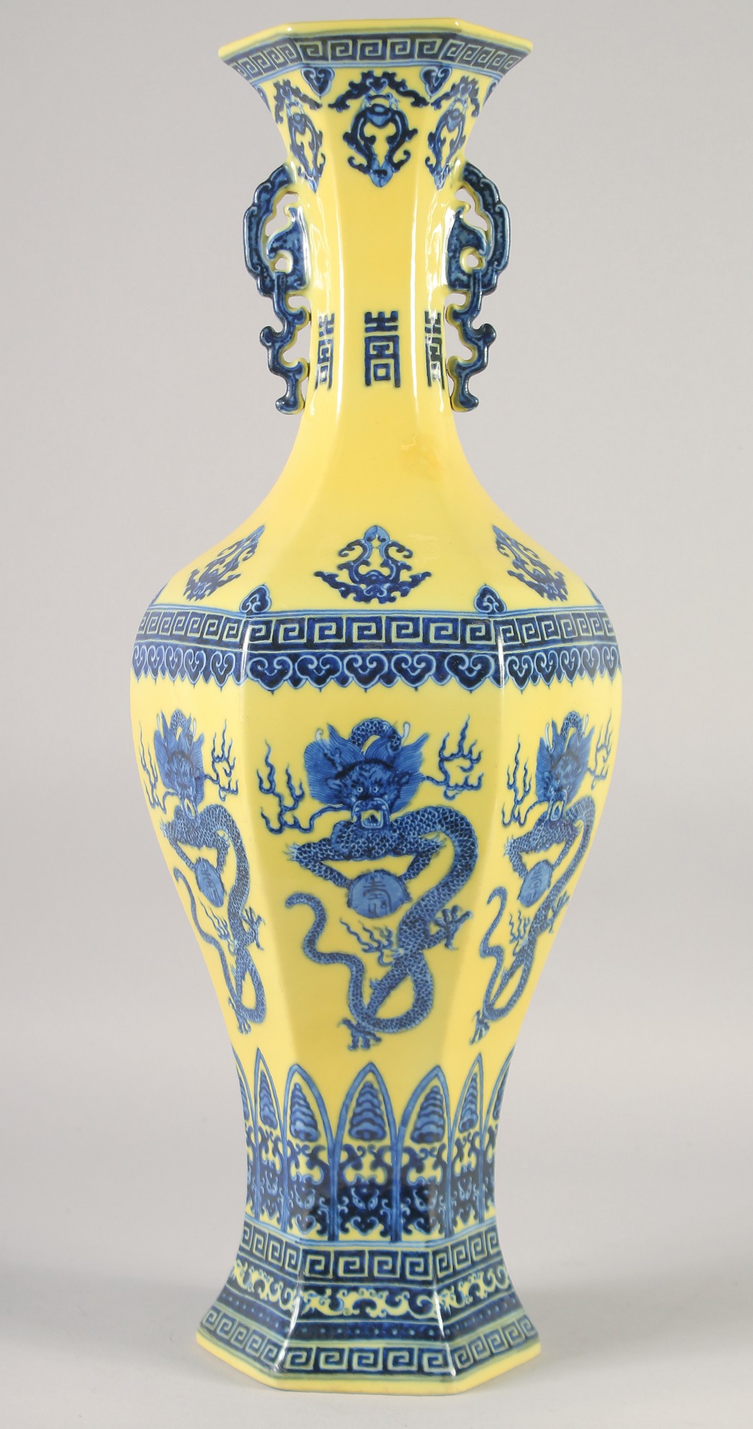 A LARGE CHINESE YELLOW GROUND BLUE AND WHITE HEXAGONAL VASE, with molded twin handles, 58cm high.