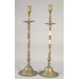 A LARGE PAIR OF ISLAMIC BRASS CANDLESTICKS, each approx. 70cm high.